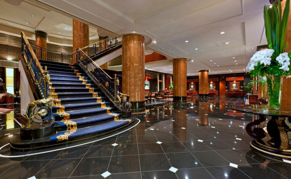 Opulent lobby at The Westin Tokyo featuring a grand staircase, marble floors, and floral decor. Accessible rooms include a roll-in shower.